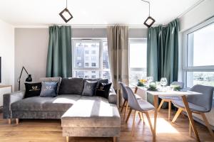 a living room with a couch and a table at Apartamenty Gdansk EU - Baltica Towers 223 in Gdańsk