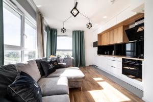 a living room with a couch and a kitchen at Apartamenty Gdansk EU - Baltica Towers 223 in Gdańsk