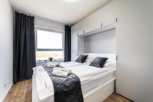 a bedroom with a large bed and a window at Apartamenty Gdansk EU - Baltica Towers 223 in Gdańsk