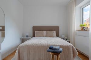 a bedroom with a bed with a blanket and a stool at Perfektes Appartement für Erholung in der Wachau!! in Spitz