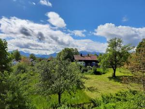 una casa en medio de un campo con árboles en Ferienwohnung Fenzl, en Rimsting