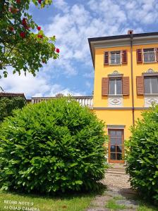 a yellow house with bushes in front of it at Villa La Palazzina in Agazzano