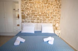 een slaapkamer met een blauw bed en handdoeken bij Anastasia Traditional House in Lardos