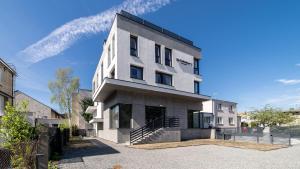 a large white building with stairs in a parking lot at Apartamenty Gdansk EU- Apartamenty Jelitkowska 11, 200m od morza in Gdańsk