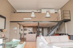 un soggiorno con divano bianco e scala di luxurious loft Oudenaarde in The Flemish Ardennes a Oudenaarde