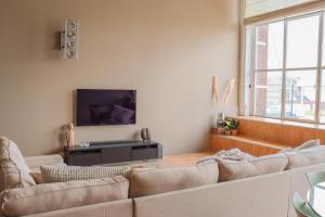 a living room with a couch and a tv at luxurious loft Oudenaarde in The Flemish Ardennes in Oudenaarde