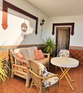 ein Wohnzimmer mit einem Sofa, einem Tisch und Stühlen in der Unterkunft Apartamentos Maria in Cómpeta