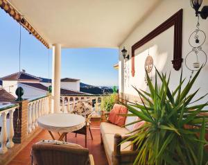 d'une terrasse avec une table et des chaises sur un balcon. dans l'établissement Apartamentos Maria, à Cómpeta