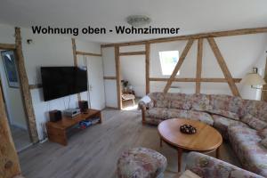 a living room with a couch and a tv at Bauernhaus Questin in Alt Bukow