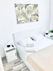 una camera bianca con un letto con lenzuola bianche di Sega Residence Alessia 22 a Mamaia Nord - Năvodari