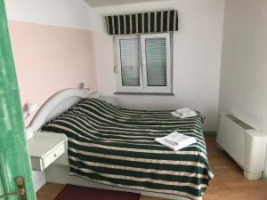 a small bedroom with a bed and a window at Pansion Dragica in Rab +33 photos