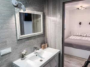 a bathroom with a sink and a mirror and a bed at Taikos 14 in Nida