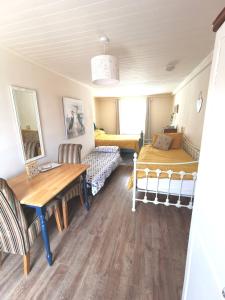 um quarto com uma mesa e uma cama e um quarto em The Nook @ Rowan Tree Cottage em Ballymoney