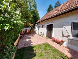 un patio di una casa con tavolo e panche di Kilátás a tóra Apartman a Szigliget