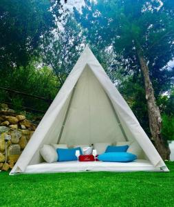 Tenda bianca con divano in erba di Villa Sardinia Seaview&SPApool a Portu sa Ruxi