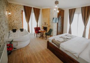 a bedroom with a tub and a bed and a bathroom at Sea House Hotel in Ağva