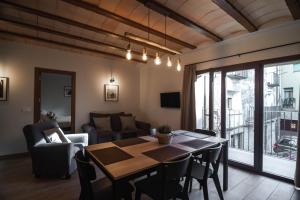 a living room with a table and chairs and a couch at Cal Negret Rural Apartments in Alós de Balaguer