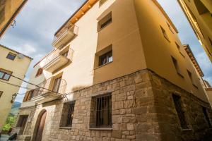 a yellow building with windows on the side of it at Cal Negret Rural Apartments in Alós de Balaguer