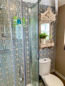 a bathroom with a toilet and a glass shower at SW Bed & Breakfast in Swindon