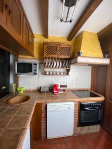 uma pequena cozinha com um lavatório e uma máquina de lavar louça em Casa Rural Azahara em Zahara de la Sierra