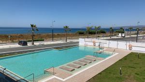 a large swimming pool with a view of the ocean at Amazing Duna Beach Seafront Apartament in Torrox