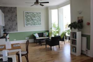 a living room with chairs and a ceiling fan at Beamsley Lodge B&B in Eastbourne
