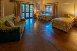 a living room with a couch and a bed at Impisi Accommodation in Phalaborwa