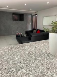 a living room with a couch and a counter top at L'escapade des randonneurs in Lautenbach