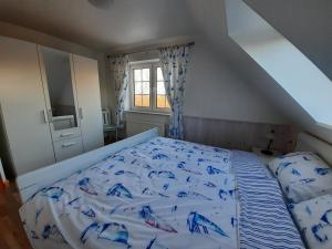 a bedroom with a bed with blue sheets and a window at Wormshöft 16 in Hasselberg