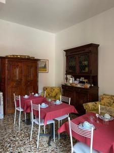 a dining room with red tables and chairs and a couch at B&B Ca' Dor in Venice