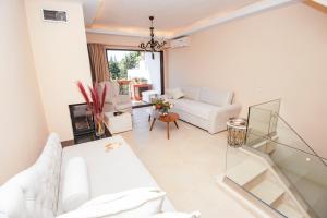 a living room with a white couch and a table at Ninos Luxury Apartment in Corfu Town