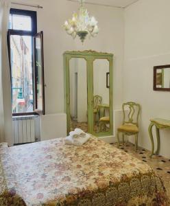 a bedroom with a bed and a mirror and a chair at B&B Ca' Dor in Venice