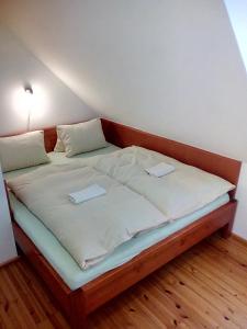 a large bed in a room with two folders on it at Hostinec u Janatů s ubytováním in Čestín
