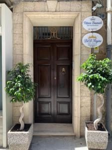 uma porta castanha com duas árvores à frente em B&B Vittorio Emanuele em Licata