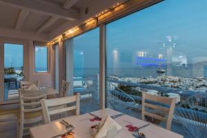 een restaurant met tafels en stoelen en uitzicht op de oceaan bij Ibiscus Boutique in Mykonos-stad