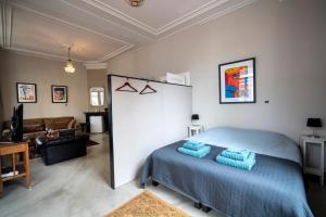 a bedroom with a blue bed and a couch at De Grift in Apeldoorn