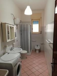 een badkamer met een wastafel en een wasmachine bij Appartamenti Boston in Marina di Camerota