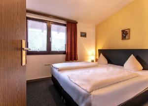 een hotelkamer met 2 bedden en een raam bij Family-Appartements in Innsbruck