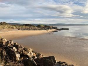 a sandy beach with rocks and the ocean at KINGDOM HOLIDAY PARK in Haverigg