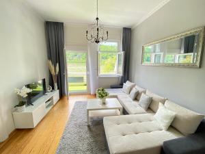 a living room with a white couch and a tv at Villa Evin in Kamp-Bornhofen