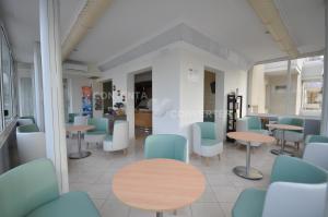 una sala de espera con sillas y mesas azules en Hotel Adriatic&Beauty en Rímini
