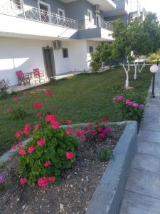 einen Garten mit rosa Blumen vor einem Gebäude in der Unterkunft Gouvia House Luxury Apartments in Gouvia