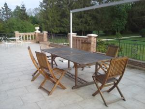 een houten tafel en stoelen op een patio bij Château des Bouffards in Brinon-sur-Sauldre