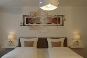 法爾維希的住宿－詩尼曼加斯特與韋恩霍夫旅館，一间卧室配有两张床和吊灯。