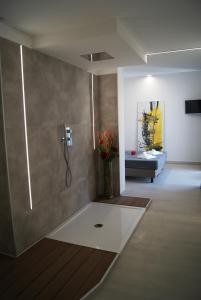 uma casa de banho com um chuveiro com um vaso de flores em Hotel Residence Sanremo em Grado