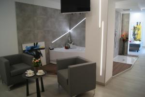 ein Wohnzimmer mit einem TV, einem Sofa und einem Tisch in der Unterkunft Hotel Residence Sanremo in Grado