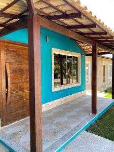 ein Haus mit einer blauen Wand und einer Holztür in der Unterkunft Casa Rasa in Búzios
