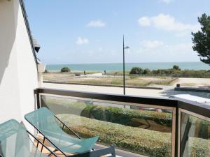 een balkon met een stoel en uitzicht op de oceaan bij Appartement Front de Mer à Carnac Plage in Carnac