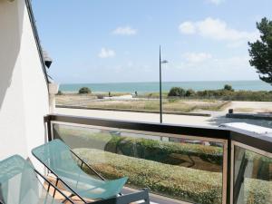 un balcon avec une chaise et une vue sur l'océan dans l'établissement Appartement Front de Mer à Carnac Plage, à Carnac
