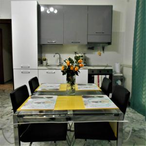 a kitchen with a table with a vase of flowers on it at MaisonFree Centro Storico in Civitavecchia